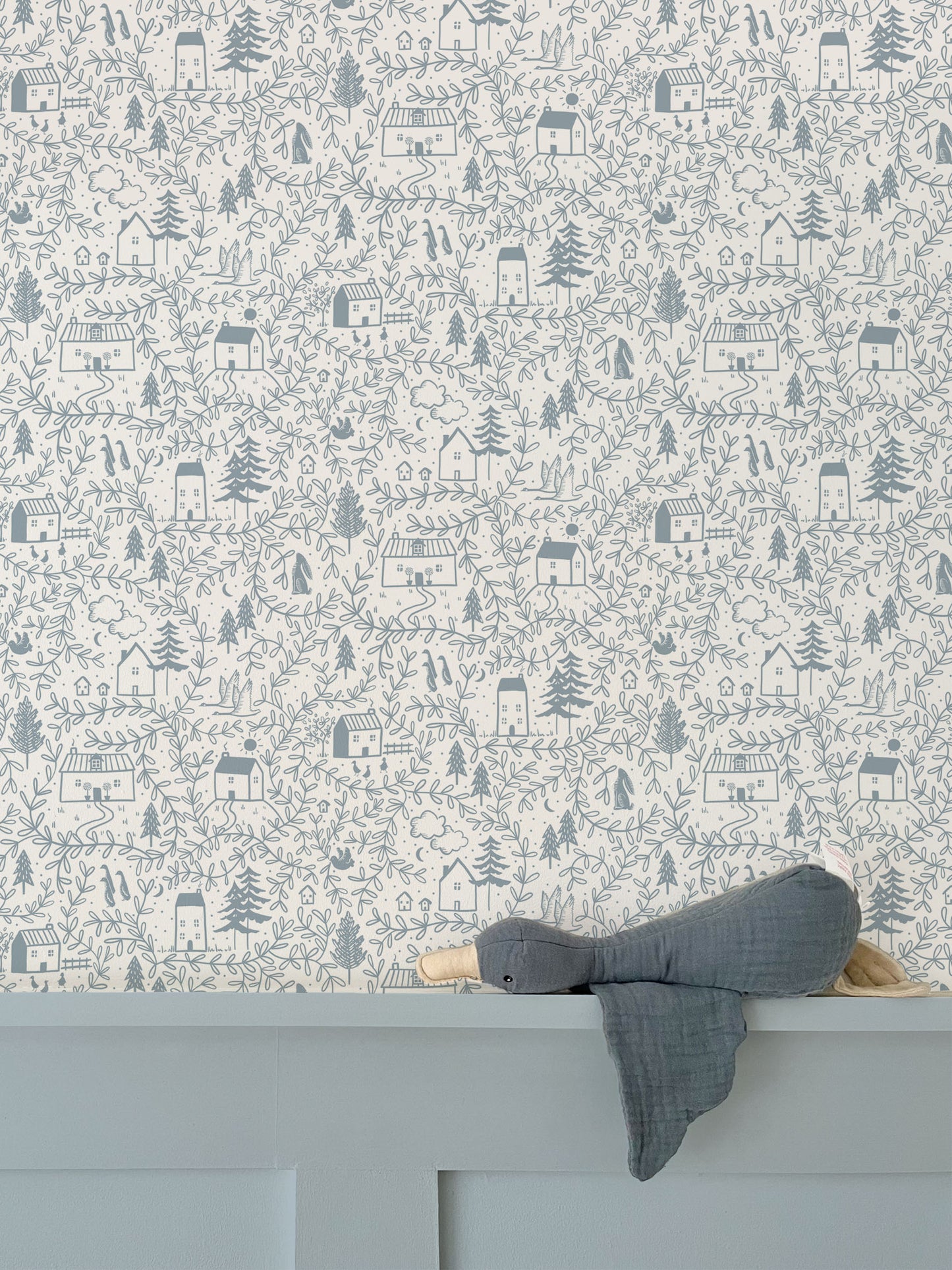 Cottages in the woods luxury children's wallpaper featured above blue wall panelling with soft toy duck