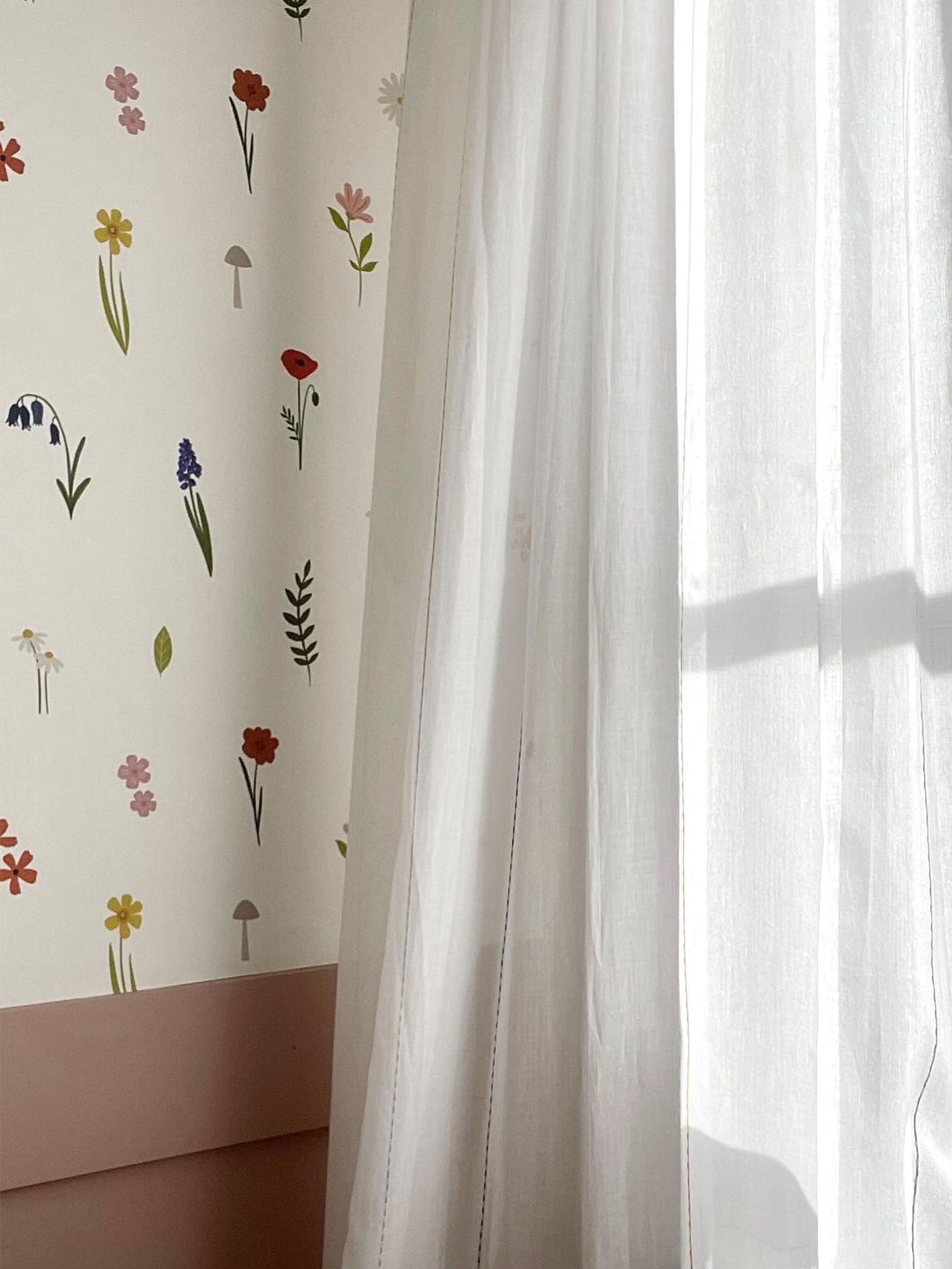 Forest Flower luxury children's wallpaper in girls bedroom above pink wall panelling with sheer white curtains